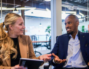 People in suits conversing in a conference room.