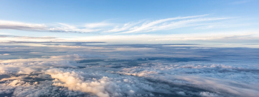 Aerial view of fluffy white clouds against a bright blue sky.