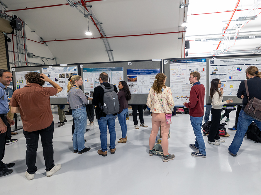 A group of people discusses projects around a poster during the ALS User Meeting Poster Session at the Lab.