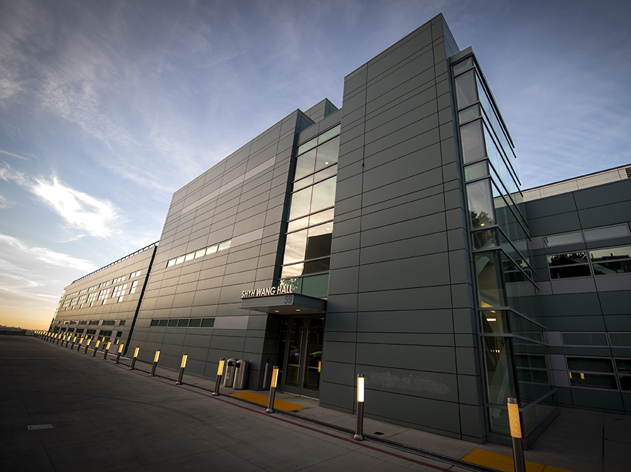 Exterior view of Shyh Wang Hall at Berkeley Lab, showcasing its large structure against a clear sky.